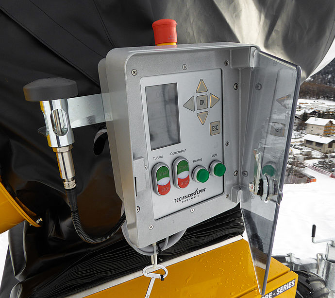 Panneau de commande d'un enneigeur TechnoAlpin avec écran et boutons de contrôle