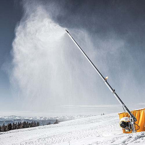 TechnoAlpin Schneilanze im Einsatz auf der Skipiste mit Alpenpanorama im Hintergrund