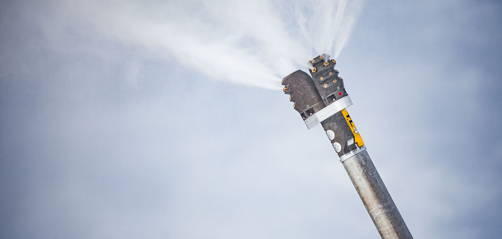 TL4 Double snow lance spraying fine water mist in front of blue-grey sky.