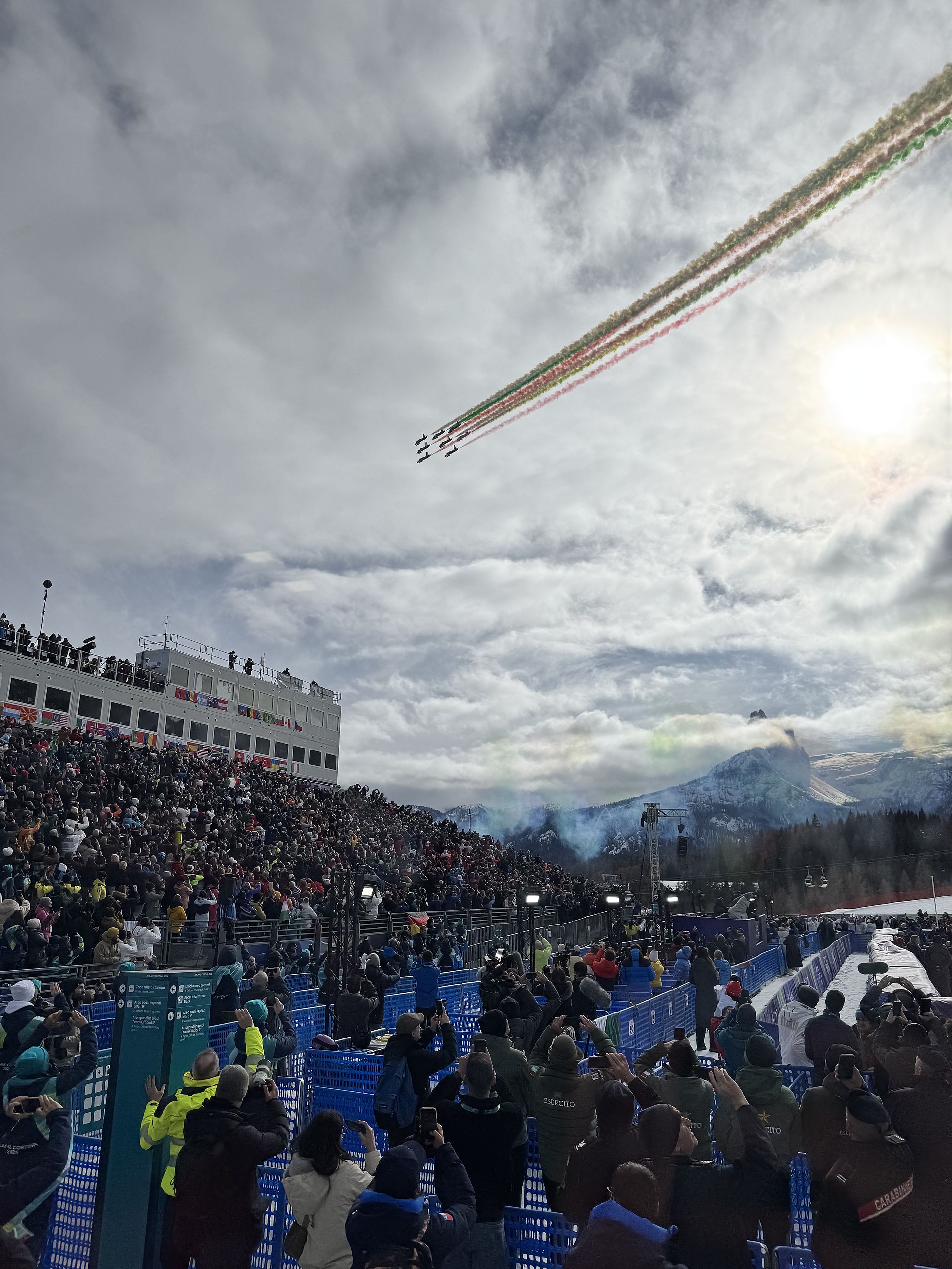 Italian Frecce Tricolori aerobatic team with green-white-red smoke over packed Olympic stadium