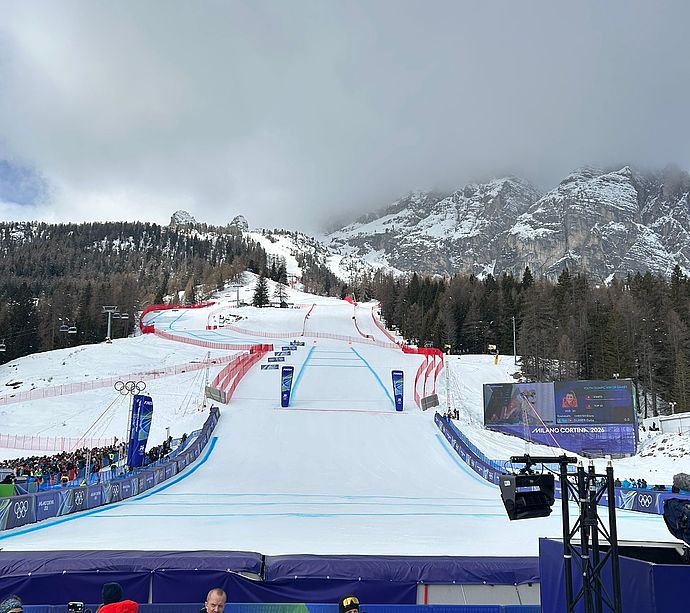 Full biathlon stadium in Anterselva with spectators and athletes in sunny mountain scenery