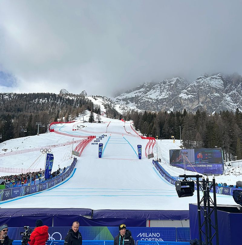 Full biathlon stadium in Anterselva with spectators and athletes in sunny mountain scenery