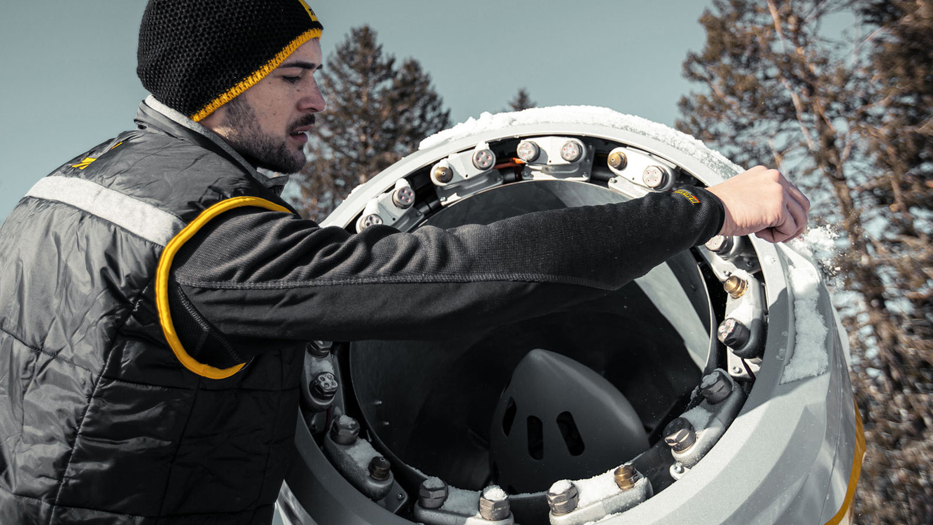 TechnoAlpin Servicetechniker prüft Propellermaschine während der Wartung im Skigebiet