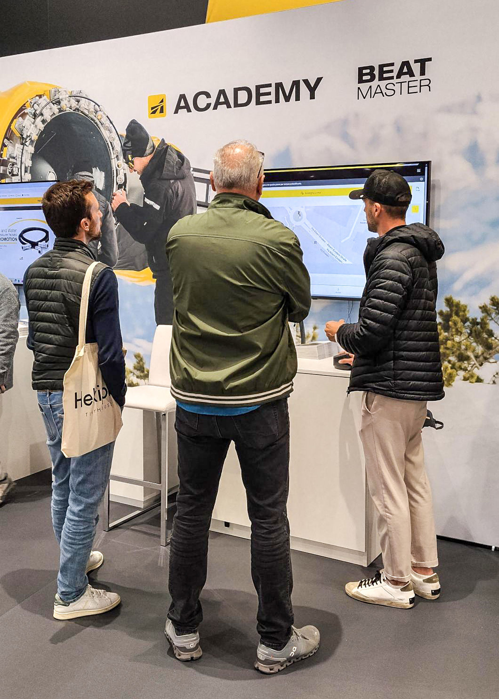 Messebesucher am TechnoAlpin Stand vor Academy- und Beatmaster-Bildschirm auf der Mountain Planet