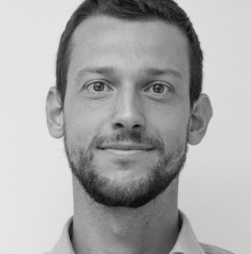 Phillipp Morandell, TechnoAlpin Mitarbeiter, Schwarz-Weiß-Portrait mit kurzem dunklem Haar, kurzem Bart und sanftem Lächeln in hellem Hemd